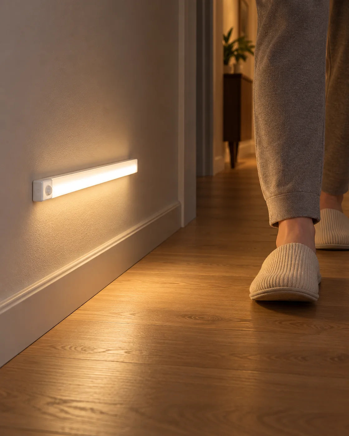 Luz con sensor instalada a baja altura en un pasillo mientras una persona pasa