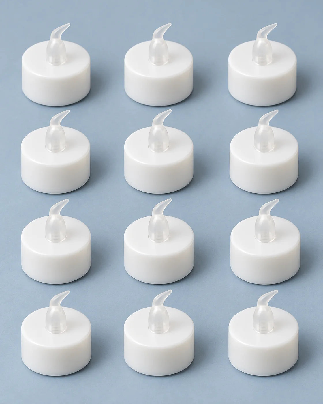 Doce pequeñas velas LED blancas organizadas en tres columnas y cuatro filas